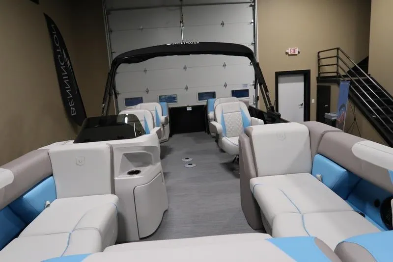 Slide: The Image of 2025 Sweetwater SW 2286 QS pontoon boat interior with modern seating in showroom. - 2