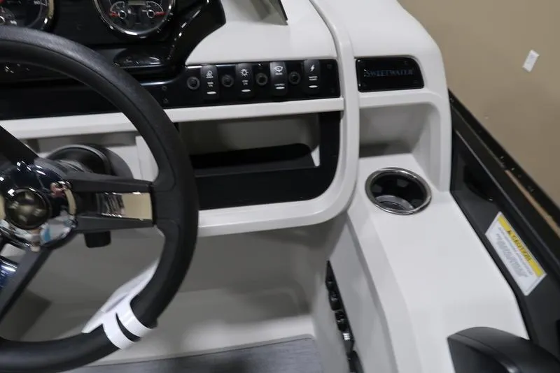 Slide: The Image of Steering console of 2025 Sweetwater SW 2286 QS boat with control panel and cup holder. - 36