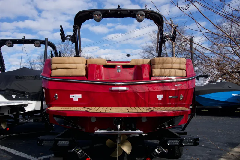 Slide: The Image of 2025 MasterCraft XT22T boat, red exterior, rear view with seating and wakeboard tower. - 2