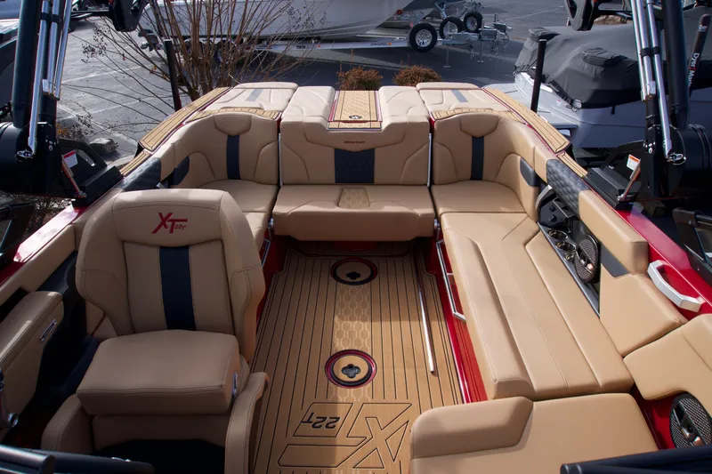 Slide: The Image of 2025 MasterCraft XT22T boat interior with tan seating and wood flooring. - 6