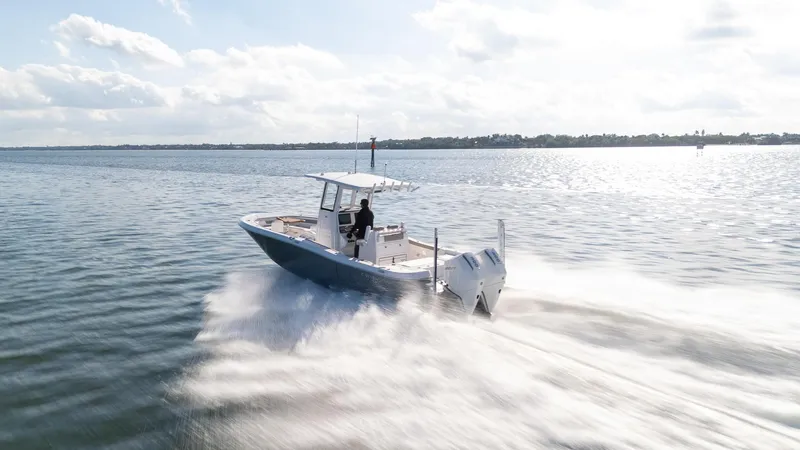 Slide: The Image of 2025 Caymas 291 boat speeding on open water under a clear sky. - 10