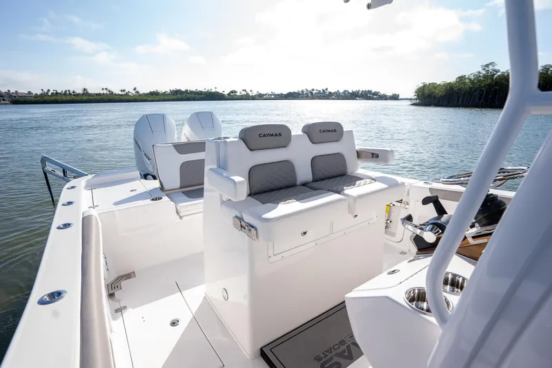 Slide: The Image of 2025 Caymas 291 boat interior with seating, on a serene water backdrop. - 13