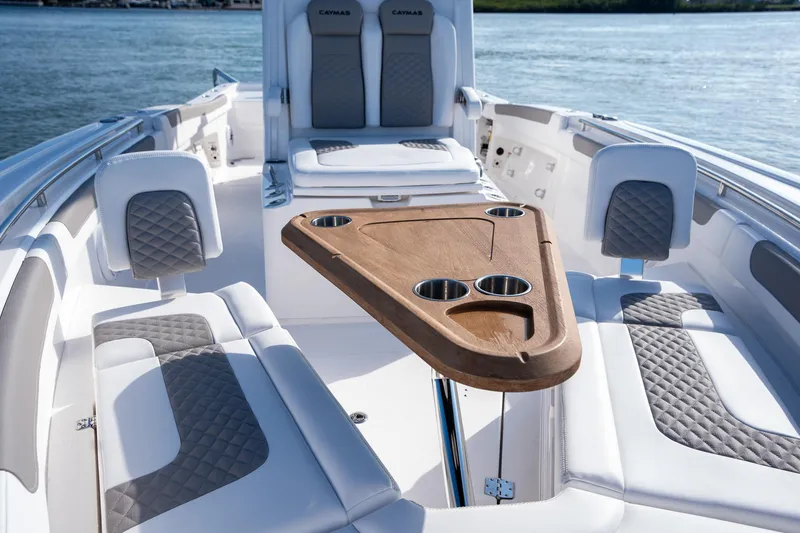 Slide: The Image of 2025 Caymas 291 boat interior with cushioned seating and wooden table on the water. - 15