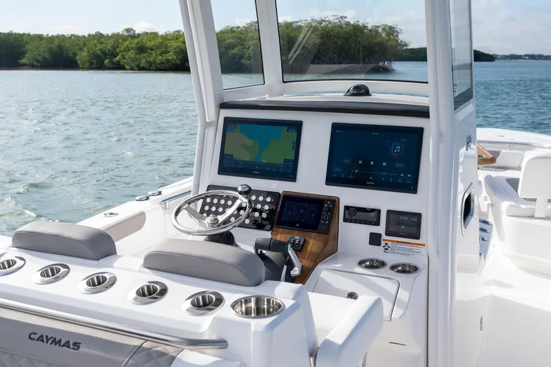 Slide: The Image of 2025 Caymas 291 boat dashboard with advanced navigation screens on a calm lake. - 23