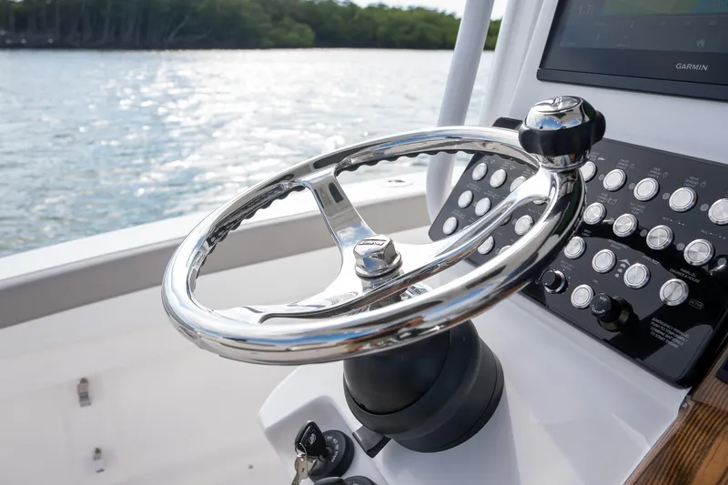 Slide: The Image of 2025 Caymas 291 boat steering wheel and control panel on water. - 27