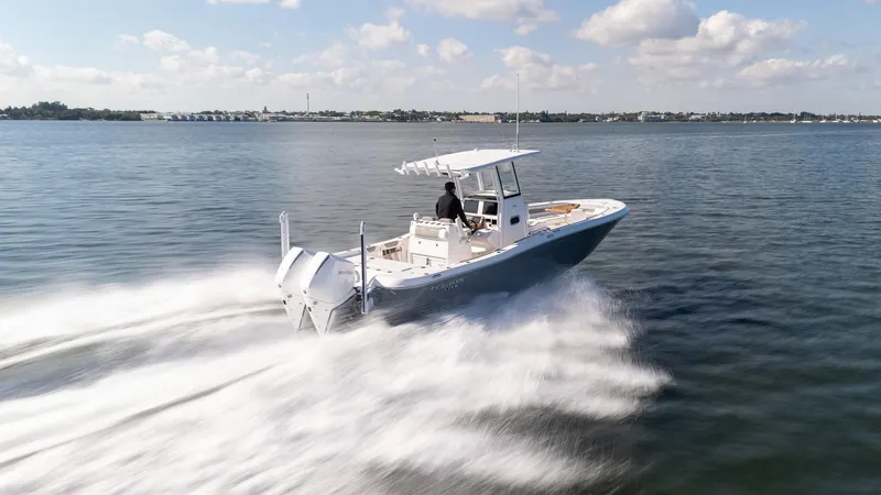 Slide: The Image of 2025 Caymas 291 boat speeding on open water under a clear sky. - 8