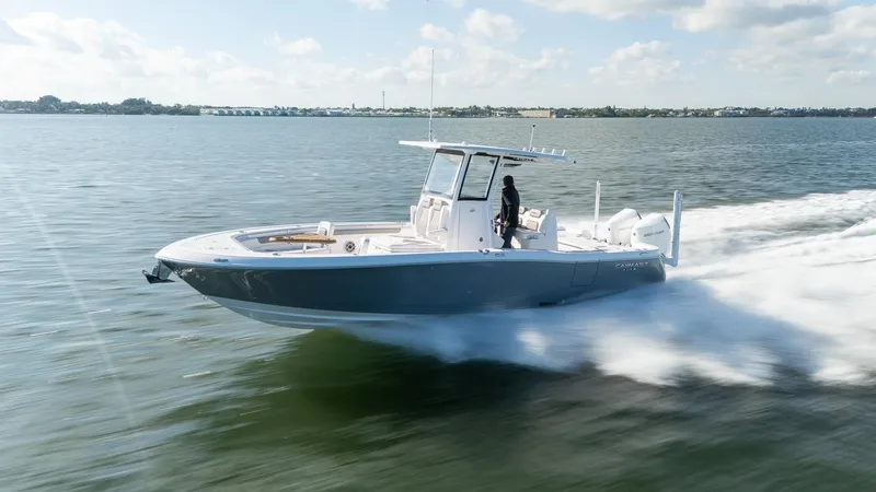 Slide: The Image of 2025 Caymas 291 boat speeding on open water under a clear sky. - 9