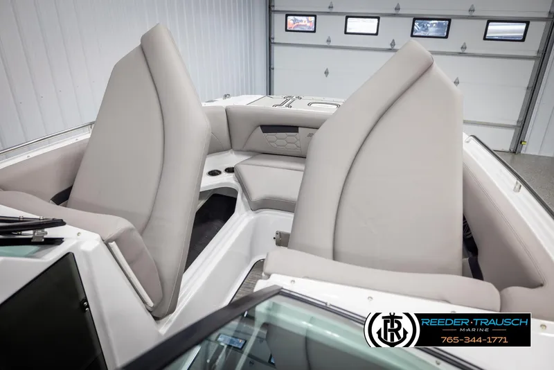 Slide: The Image of 2025 Four Winns HD5 boat interior with beige seating in a showroom. - 22