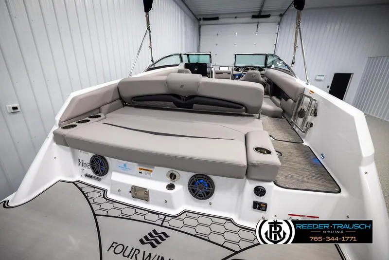 Slide: The Image of 2025 Four Winns HD5 boat interior with spacious seating and modern design in a showroom. - 32