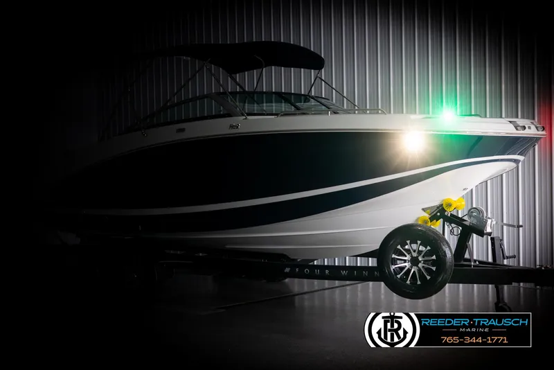 Slide: The Image of 2025 Four Winns HD5 boat in a dimly lit showroom with trailer. - 4