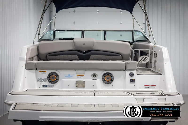Slide: The Image of 2025 Four Winns HD5 boat rear view with seating and speakers, displayed indoors. - 7