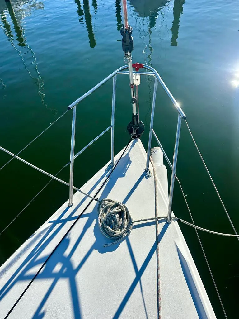 Slide: The Image of Bow of 2006 J Boats J/92S sailboat with coiled rope, docked on calm water. - 19