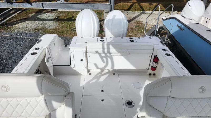 Slide: The Image of 2023 Edgewater 280 CX boat interior with white seating and dual engines. - 11