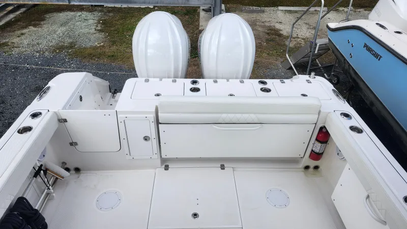 Slide: The Image of 2023 Edgewater 280 CX boat deck with dual engines and storage compartments. - 12