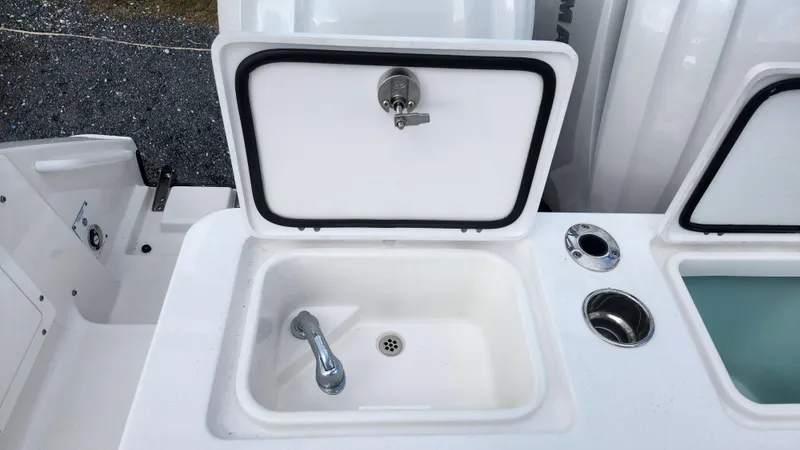 Slide: The Image of Edgewater 280 CX 2023 boat sink with faucet and storage compartment. - 14