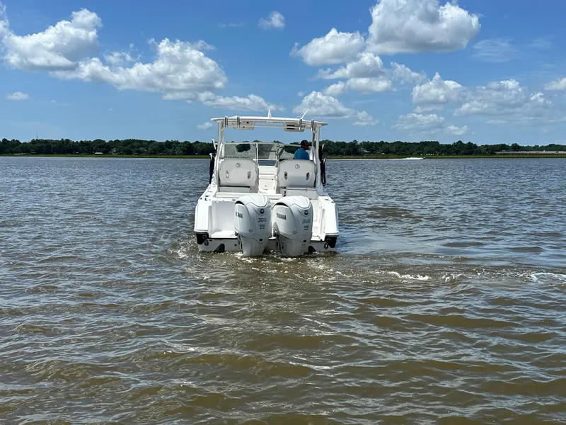 Slide: The Image of 2023 Edgewater 280 CX boat cruising on a sunny day with clear skies. - 2