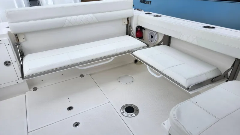 Slide: The Image of 2023 Edgewater 280 CX boat interior with white cushioned seating and storage compartments. - 21