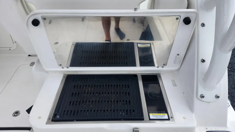 Slide: The Image of Edgewater 280 CX 2023 boat grill station with reflective cover and control panel. - 25