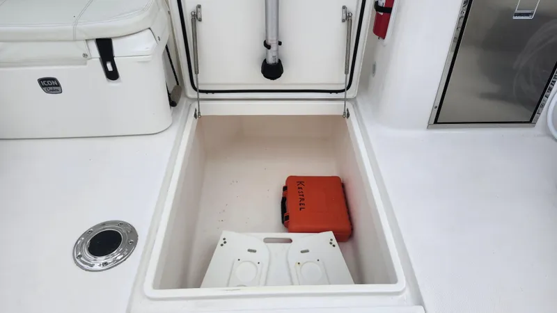 Slide: The Image of Edgewater 280 CX 2023 boat storage compartment with orange Kessel case. - 27