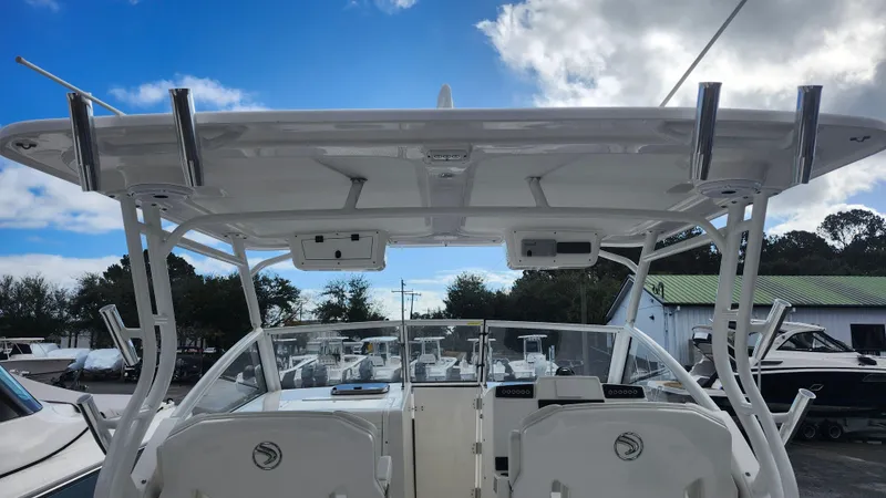 Slide: The Image of 2023 Edgewater 280 CX boat with dual consoles and T-top under a blue sky. - 29