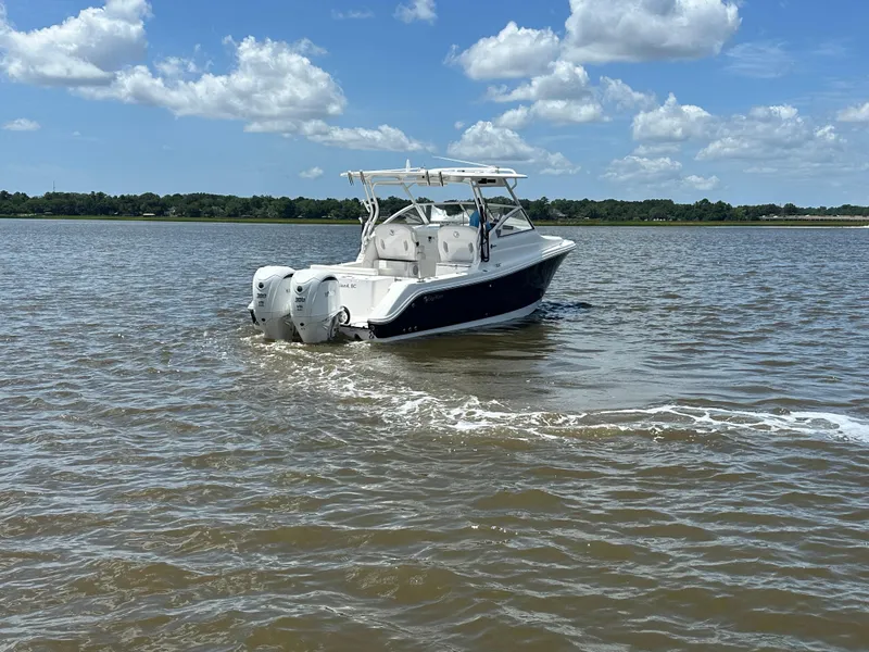 Slide: The Image of 2023 Edgewater 280 CX boat cruising on a sunny day with blue skies and clouds. - 3