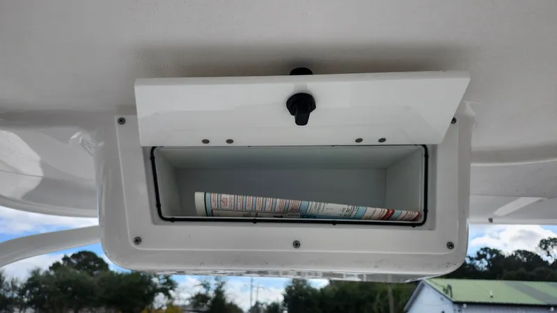 Slide: The Image of Edgewater 280 CX 2023 storage compartment with rolled-up map inside. - 30