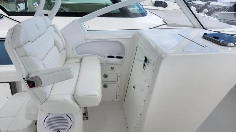Slide: The Image of 2023 Edgewater 280 CX boat interior with white seating and storage compartments. - 33