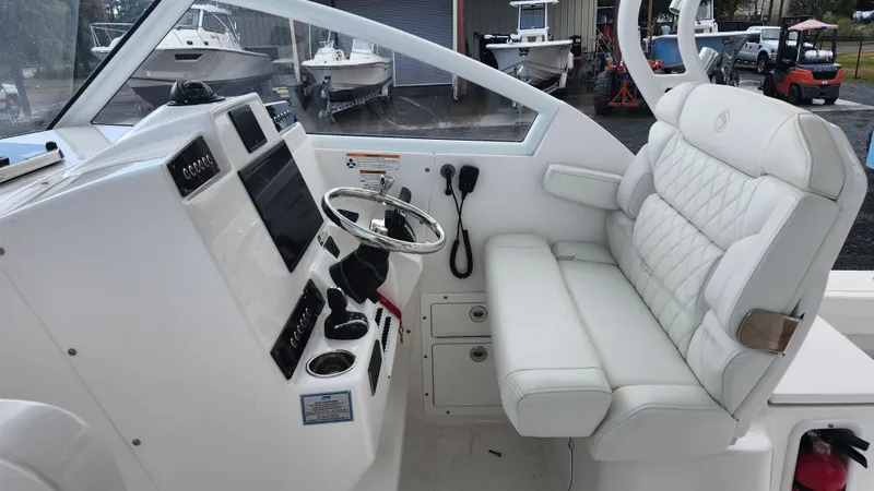 Slide: The Image of 2023 Edgewater 280 CX boat interior with white leather seating and modern dashboard. - 38