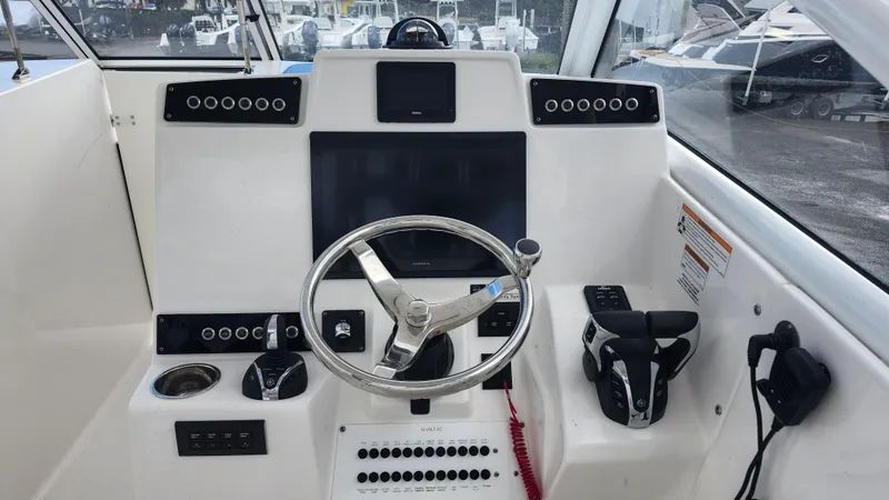 Slide: The Image of 2023 Edgewater 280 CX boat helm with modern controls and steering wheel. - 39