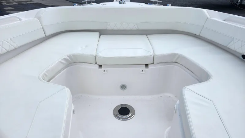 Slide: The Image of Edgewater 280 CX 2023 boat interior with white cushioned seating. - 48
