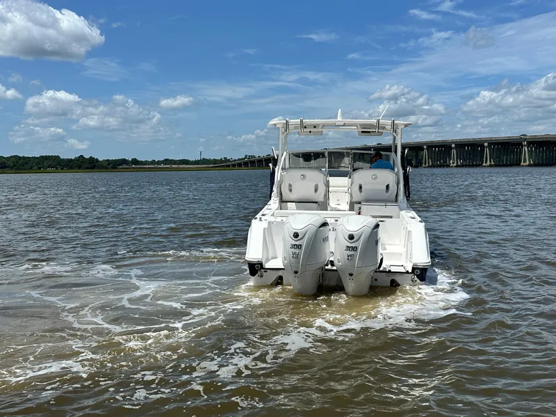 Slide: The Image of 2023 Edgewater 280 CX boat cruising on a sunny day near a bridge. - 7