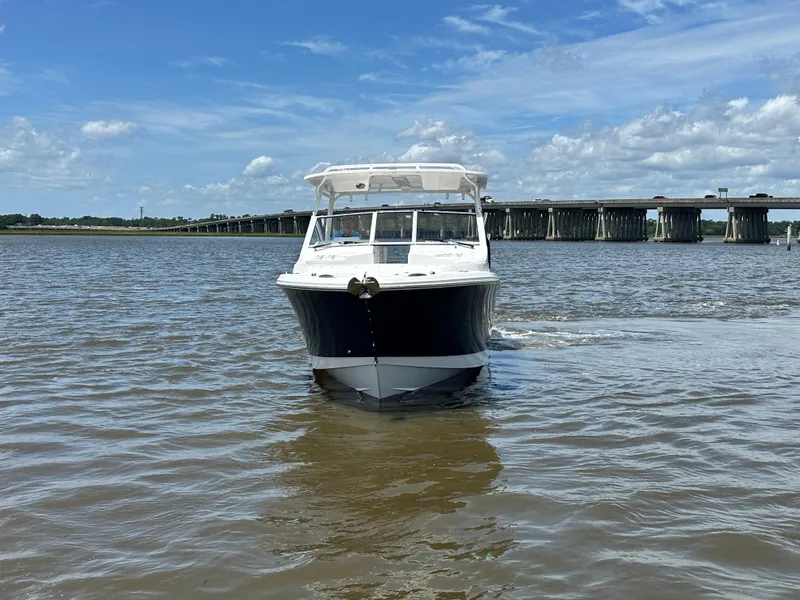 Slide: The Image of 2023 Edgewater 280 CX boat on water, with bridge and cloudy sky background. - 8