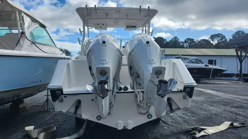 Slide: The Image of 2023 Edgewater 280 CX boat with dual outboard engines, docked outdoors. - 9