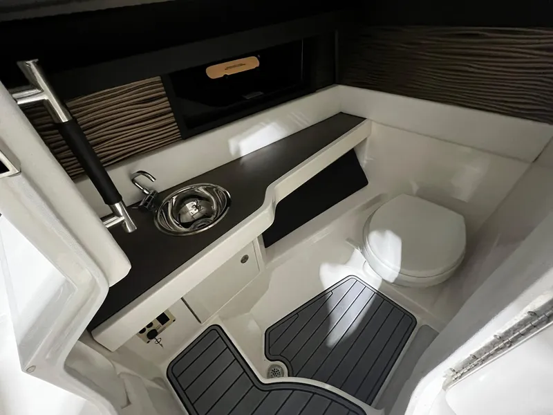 Slide: The Image of Interior of 2016 Sea Ray 310 SLX boat featuring a compact bathroom with sink and toilet. - 13