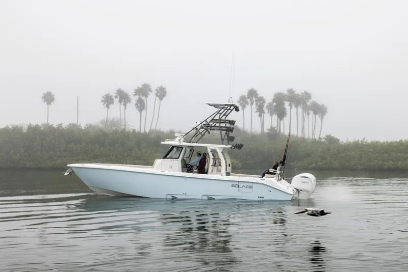 The Image of 2025 Solace 37 CS boat cruising on a foggy lake with palm trees in the background. - 0