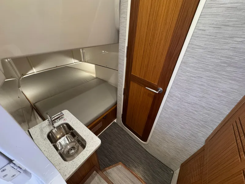 Slide: The Image of Interior of 2025 Solace 37 CS boat with sink, bed, and wooden door. - 8