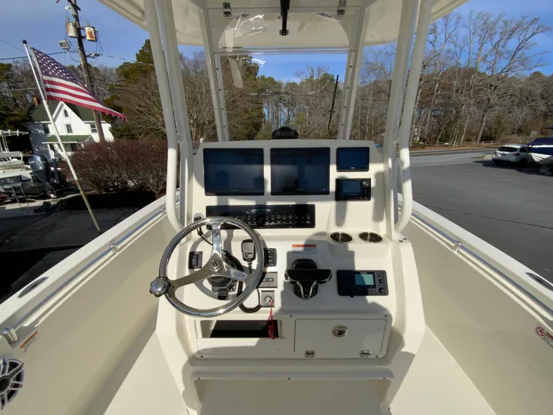 Slide: The Image of 2024 Cobia 240 Center Console boat dashboard with steering wheel and navigation screens. - 12