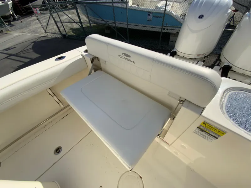 Slide: The Image of 2024 Cobia 240 Center Console boat with foldable rear seat and dual engines. - 15