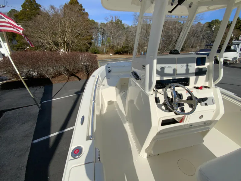 Slide: The Image of 2024 Cobia 240 Center Console boat with steering wheel and dashboard, parked outdoors. - 17