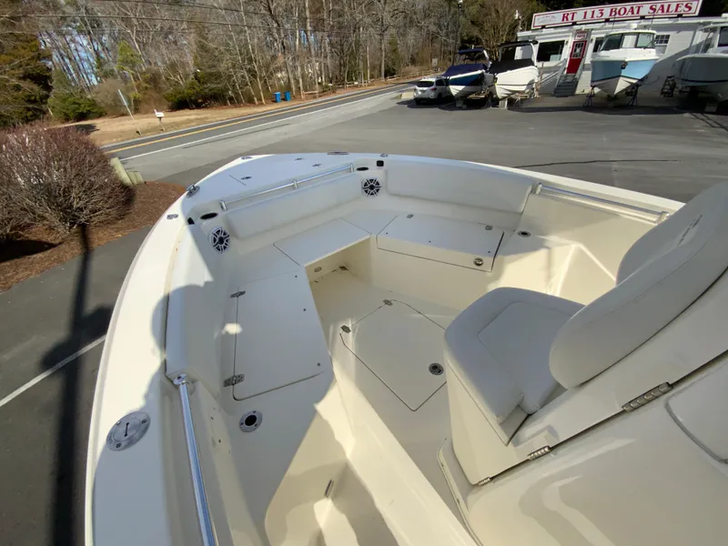 Slide: The Image of 2024 Cobia 240 Center Console boat interior at dealership, showcasing seating and storage. - 18