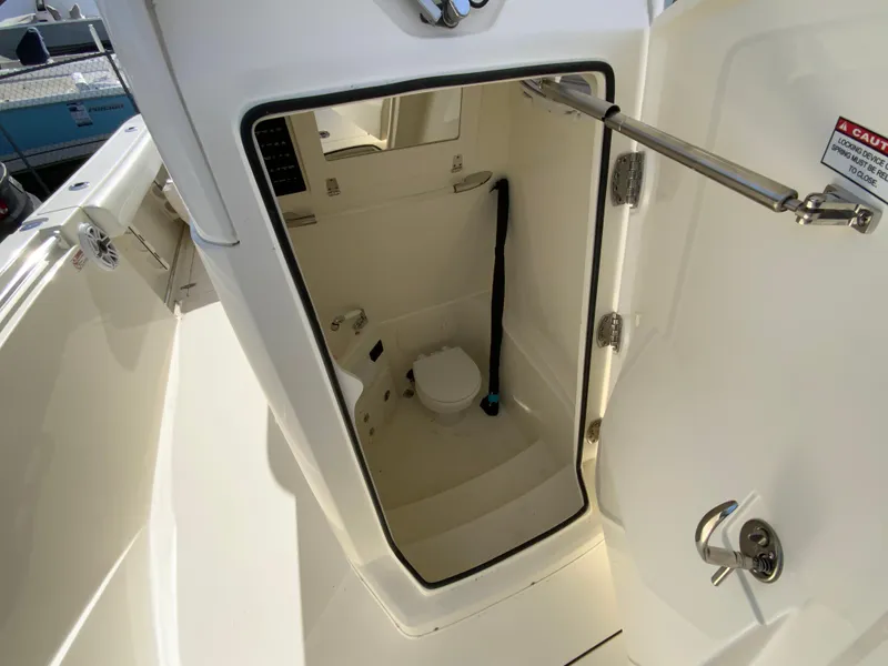 Slide: The Image of 2024 Cobia 240 Center Console boat interior with compact marine toilet. - 27