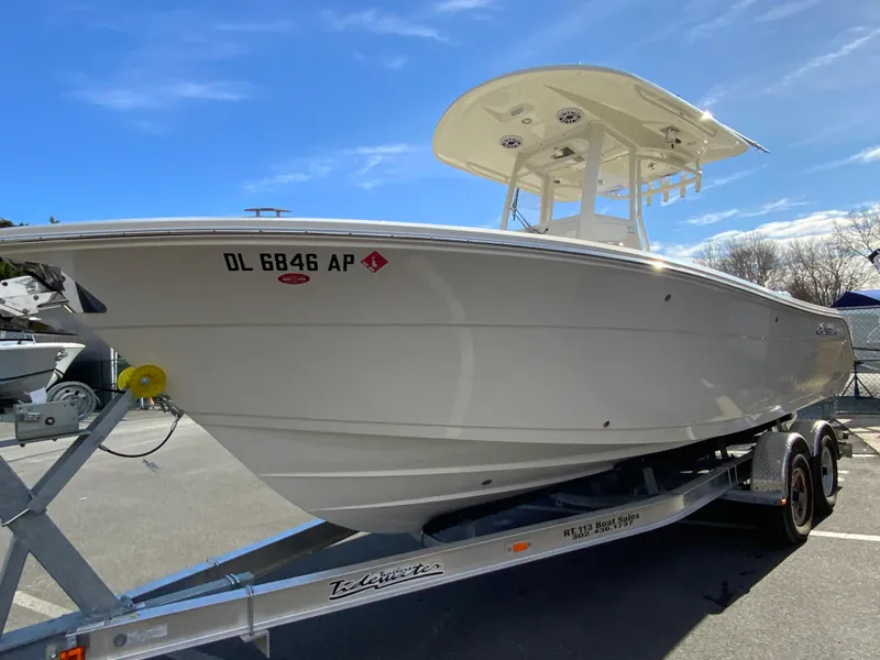 Slide: The Image of 2024 Cobia 240 Center Console boat on trailer under clear blue sky. - 5
