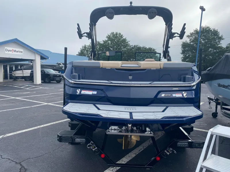 Slide: The Image of 2025 MasterCraft NXT21 boat in parking lot, rear view. - 3