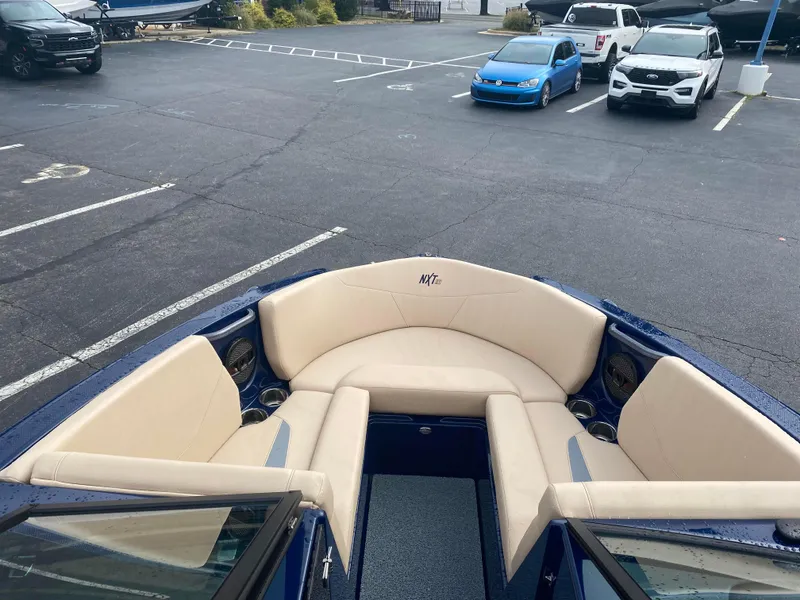 Slide: The Image of 2025 MasterCraft NXT21 boat with beige seating in a parking lot. - 4