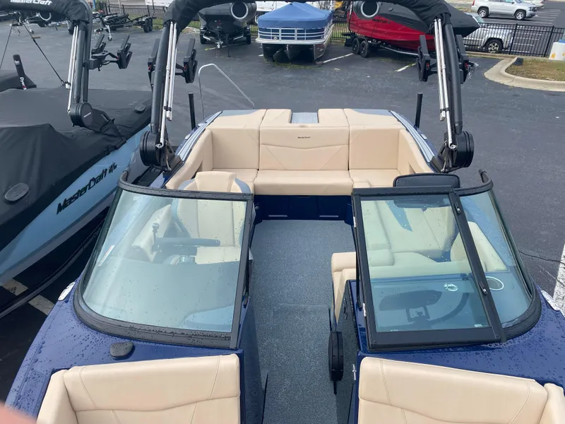 Slide: The Image of 2025 MasterCraft NXT21 boat with beige seating and dual windshields. - 7