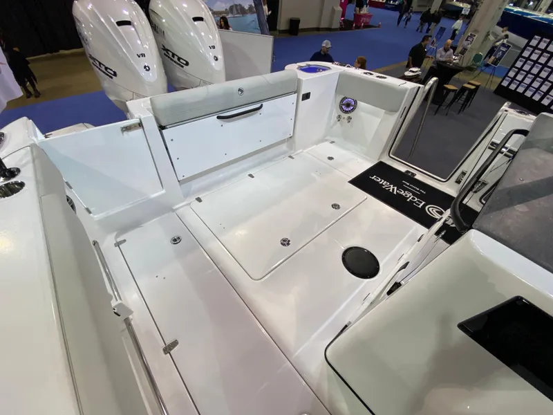 Slide: The Image of 2025 Edgewater 340CC boat deck with dual outboard engines, showcased at a marine exhibition. - 2