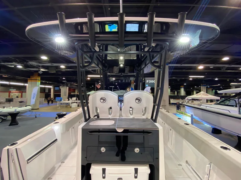 Slide: The Image of 2025 Edgewater 340CC boat interior at a showroom, showcasing seating and control panel. - 3