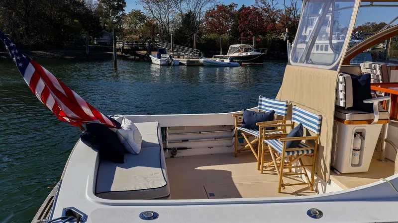 Slide: The Image of 2008 Fortier 33 boat with seating area, docked in a serene marina. - 14
