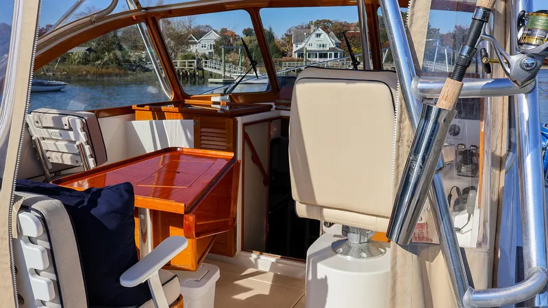 Slide: The Image of Interior of 2008 Fortier 33 boat with wooden table and fishing rod holder. - 16