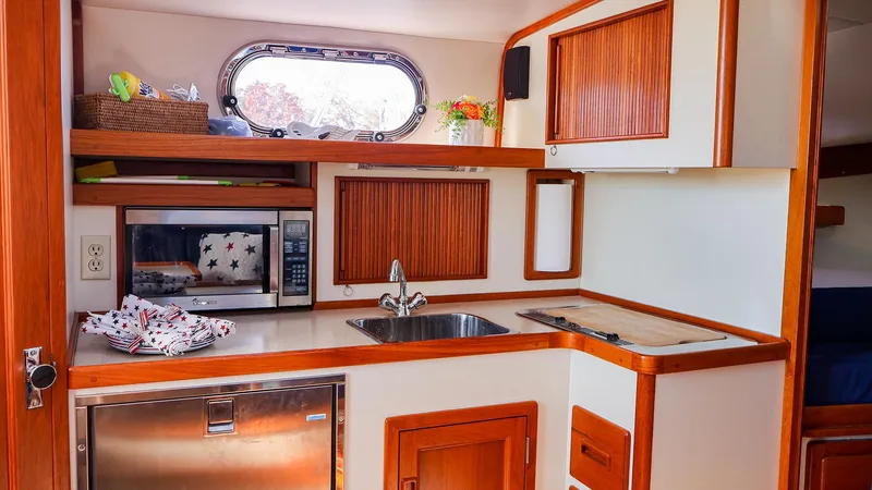 Slide: The Image of 2008 Fortier 33 boat kitchen with wood accents, sink, and microwave. - 20